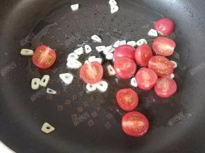 放入小番茄，略微煸炒至番茄皮起皱