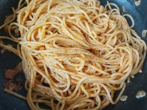 将酱汁和意面拌匀，使酱汁都裹在面条上，放入一点现磨黑胡椒粉