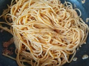 将酱汁和意面拌匀，使酱汁都裹在面条上，放入一点现磨黑胡椒粉