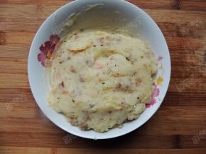 将炒好的料连同土豆泥一起装入碗中混合均匀