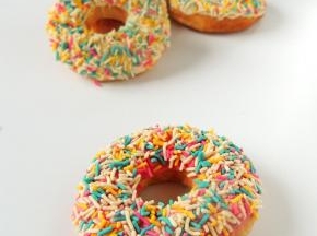 炸好的甜甜圈完全冷却以后，粘上融化的巧克力，撒上彩色糖针装饰，就可以吃了