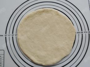 把醒发好的面团擀成中间薄周围厚的圆形面饼，大小比空气炸锅的炸篮底部略小