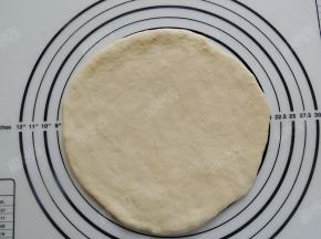 把醒发好的面团擀成中间薄周围厚的圆形面饼，大小比空气炸锅的炸篮底部略小