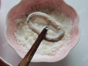 把鱿鱼圈放淀粉里滚一下