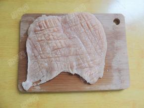 用刀背在肉片的两面逆着肉纤维轻剁