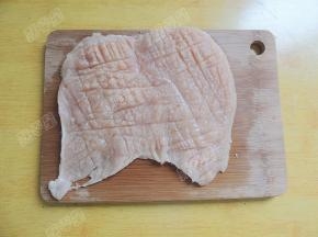 用刀背在肉片的两面逆着肉纤维轻剁