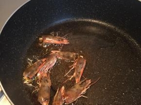 热锅冷油下虾头炼油，当锅内油呈金黄色后，弃虾头