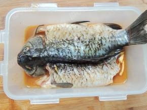 将鱼放入孜然烤肉料中，用手抹匀帮其入味，腌制两个小时