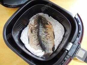 在空气炸锅的炸篮底部铺上一层锡箔纸，将腌制入味的鲫鱼放在锡纸上