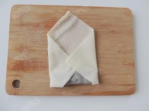 卷住馅料后再把左右两边的春卷皮向中间折，封住两端的开口