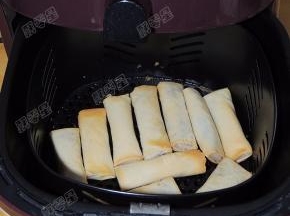 加热五分钟后取出炸篮，将春卷翻面，再刷一层油后继续加热五分钟。炸制时间结束后取出即可