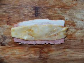 取一片培根，放上一片杏鲍菇