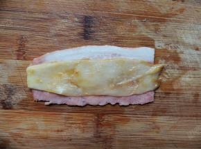 取一片培根，放上一片杏鲍菇