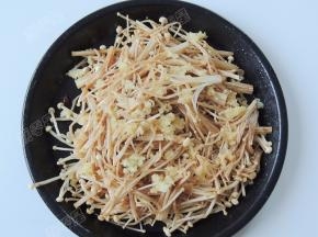 再将蒜蓉撒在金针菇表面