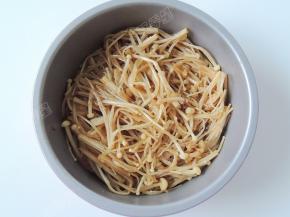 准备一个能放入空气炸锅并且耐高温的容器，将金针菇放入