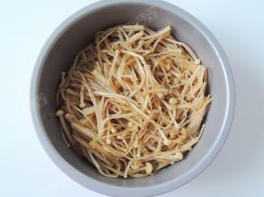 准备一个能放入空气炸锅并且耐高温的容器，将金针菇放入