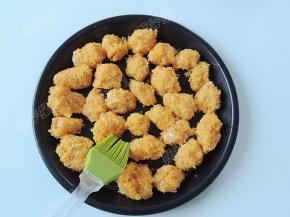 空气炸锅200度预热五分钟，预热炸锅的时候在鸡米花生坯表面刷一层薄油