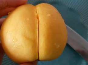 用水果刀在黄桃中间割条口子
