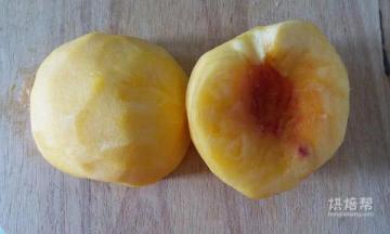 把黄桃一分为二，去皮