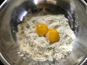 搓成面包屑状的粗粒，再加入两个蛋黄。
