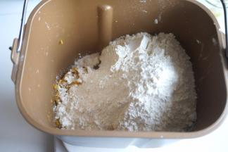 红薯去外皮，用勺子按压成泥，入面包桶内，再倒入面粉，酵母