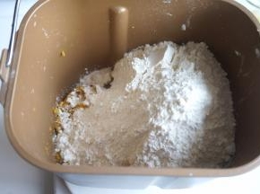 红薯去外皮，用勺子按压成泥，入面包桶内，再倒入面粉，酵母