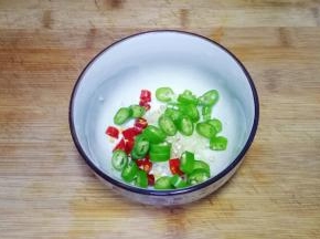 将蒜去皮，压成蒜泥，红辣椒切小段，青辣椒切成辣椒圈放入碗中