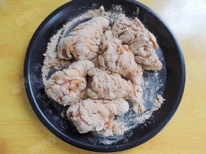 脆皮炸鸡粉倒入浅盘，将腌制好的鸡翅根均匀裹上一层炸鸡粉。