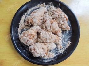 脆皮炸鸡粉倒入浅盘，将腌制好的鸡翅根均匀裹上一层炸鸡粉。