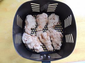 空气炸锅200℃预热5分钟，将裹好粉的鸡翅根放进炸篮内。