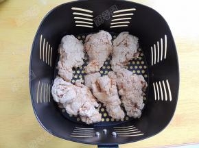 空气炸锅200℃预热5分钟，将裹好粉的鸡翅根放进炸篮内。