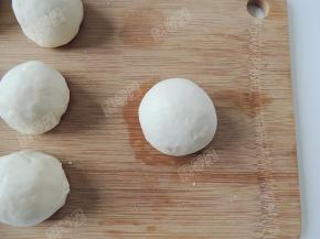 将红豆沙馅包好搓圆收口向下。