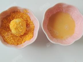 取一个包好的面团先沾鸡蛋液，再裹面包糠。