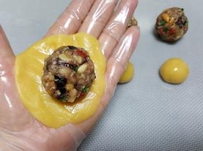 8．将一份馅料放在饼皮上，包裹馅料时，尽量避免饼皮与馅料中间有空气。