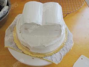 用淡奶油抹平表面和四周，注意书的表面要用奶油做出高低的弧度，侧面用三角齿形刮刀做出书页的样子