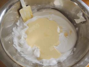 然后将翻拌好的蛋黄糊全部倒入蛋白盆中