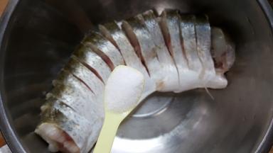 4．把鱼放在容器中加盐，抹遍鱼的全身。