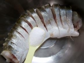 4．把鱼放在容器中加盐，抹遍鱼的全身。