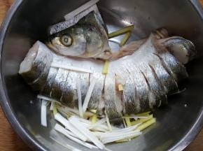 7．葱姜丝放入盛有鱼的容器中，腌30分钟。