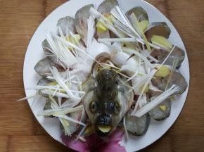 14．鱼身上再铺一层葱姜丝。