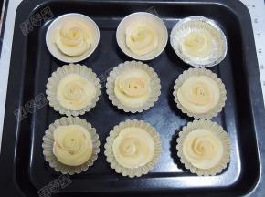 卷好的玫瑰苹果卷整理好，放入蛋挞模里，然后放在烤盘上