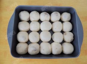 取一份面团按扁，再次滚圆，放入烤盘中