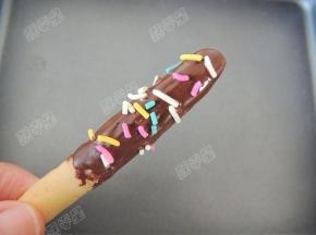 将融化的黑巧克力液淋在手指饼干上