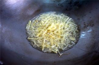 鱼蒸好后，开始处理剩下的姜丝：用滚油爆炒十来秒。