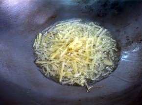 鱼蒸好后，开始处理剩下的姜丝：用滚油爆炒十来秒。