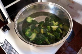 往自动烹饪锅加入1500L的清水，高火烧开后加入西兰花，姜片，少许油，将西兰花煮熟。