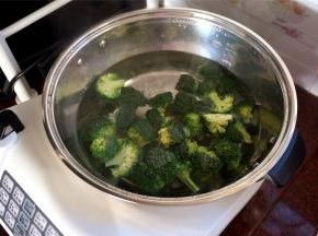 往自动烹饪锅加入1500L的清水，高火烧开后加入西兰花，姜片，少许油，将西兰花煮熟。