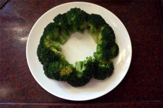 将煮熟了的西兰花夹起，摆放到碟子上，围成一个环。