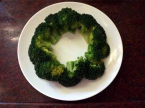 将煮熟了的西兰花夹起，摆放到碟子上，围成一个环。