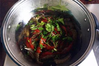 在四周倒入清水，香草铺放在大虾表面。